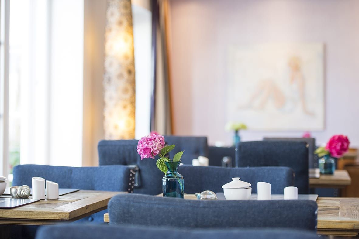 Eingedeckte Tischen im Frühstücksraum im Hotel Hof Galerie in Morsum auf Sylt