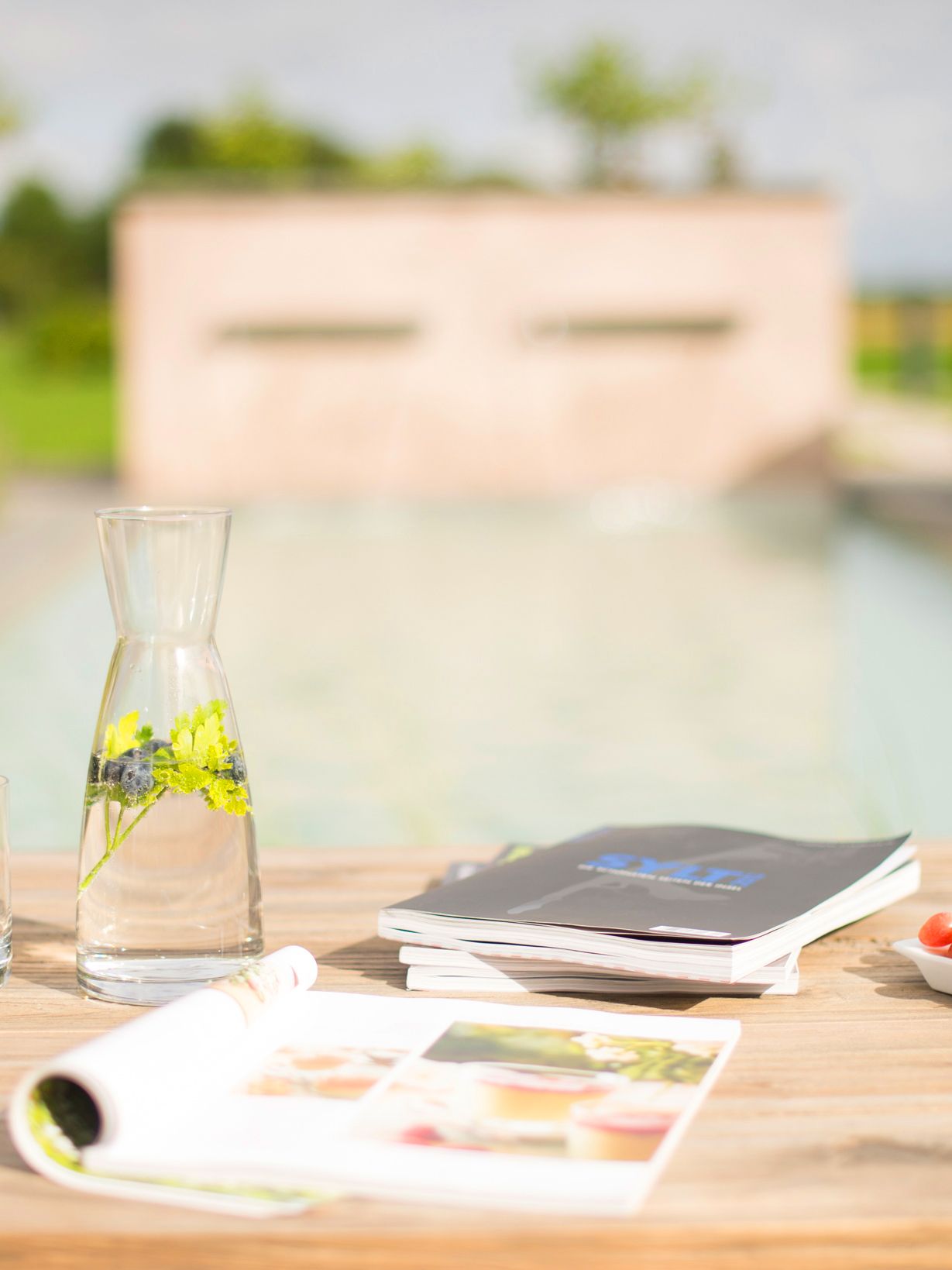 Tisch mit Getränken auf Terrasse Blick auf Pool im Hotel Hof Galerie Morsum
