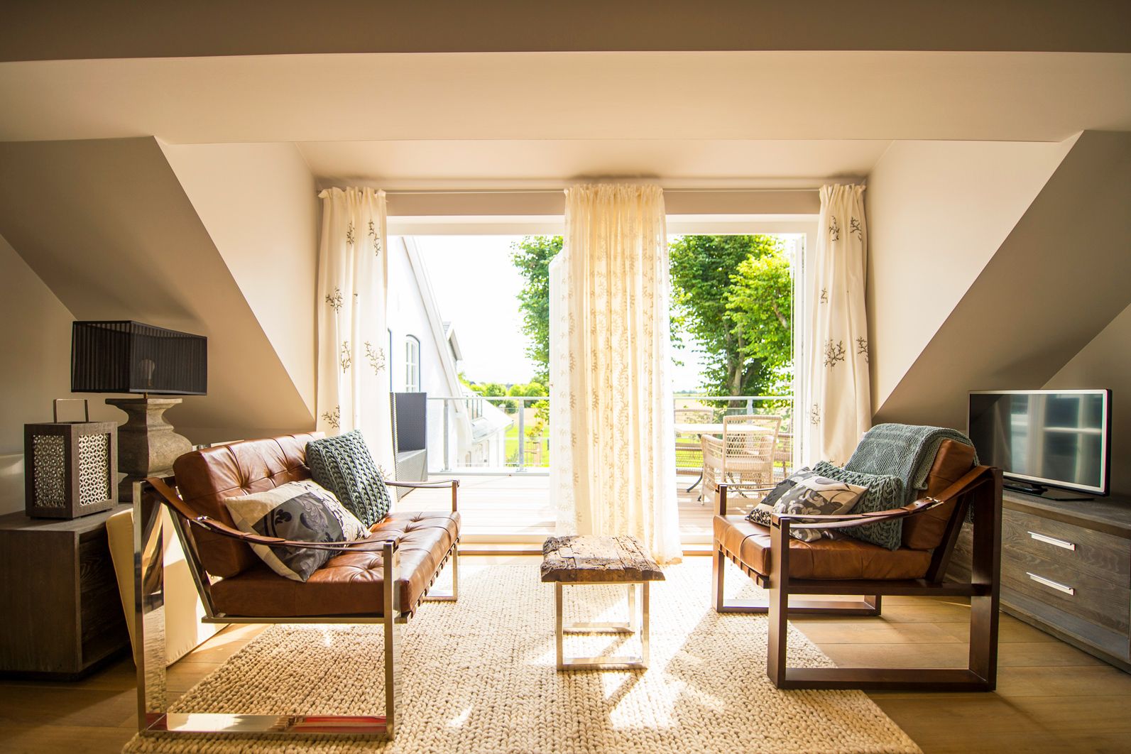 Wohnbereich mit Sesseln und Zugang zur Terrasse in der Hof Suite im Hotel Hof Galerie