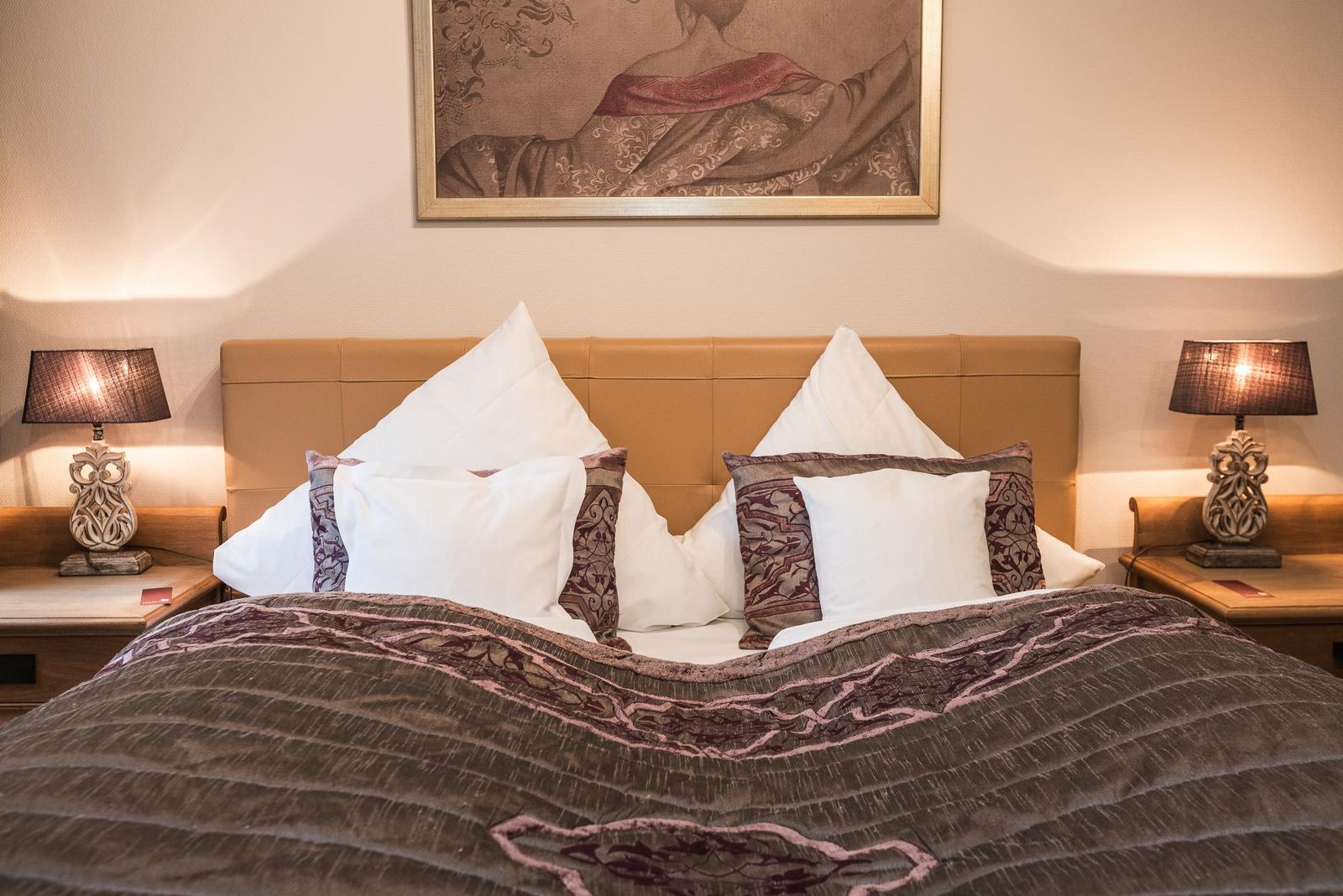 Bett mit Kissen in weiß und Bronze im Hotel Landhaus Sylter Hahn in Westerland auf Sylt
