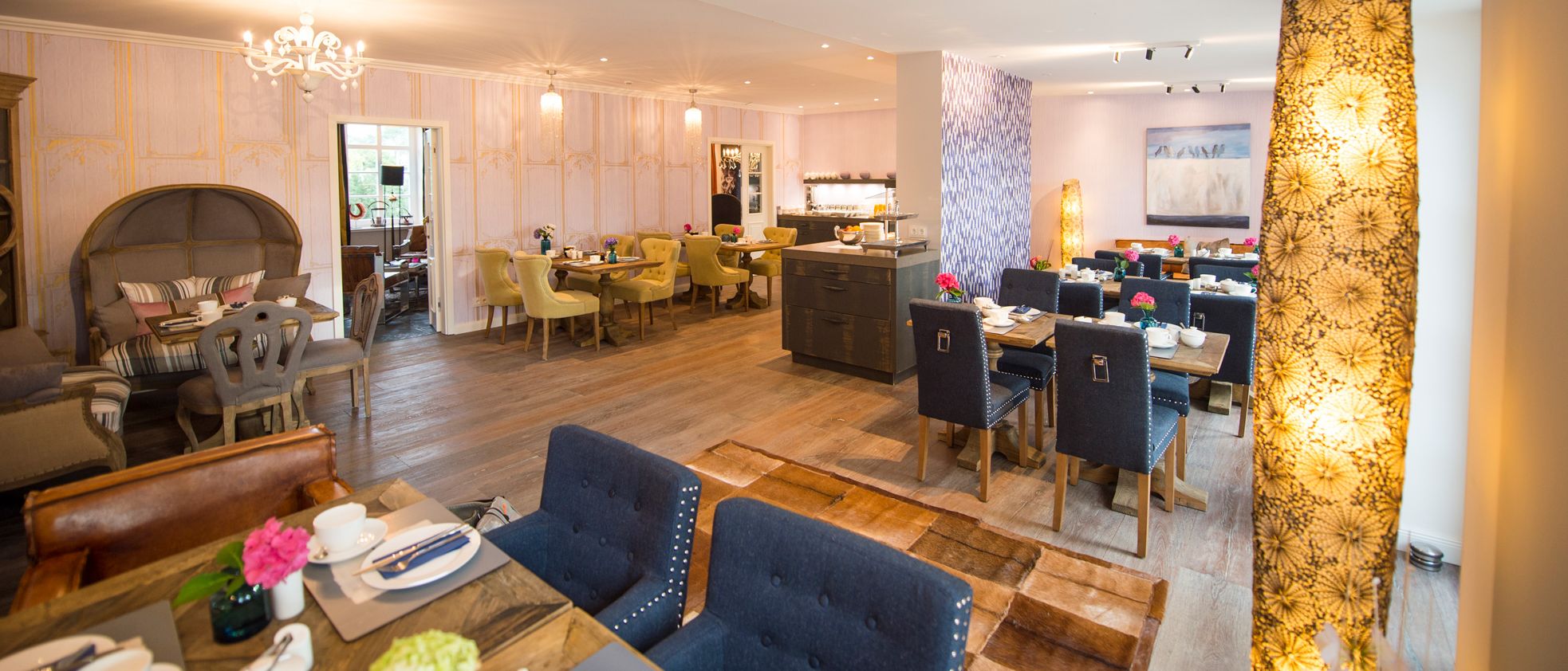 Frühstückraum mit eingedeckten Tischen im Hotel Hof Galerie in Morsum auf Sylt