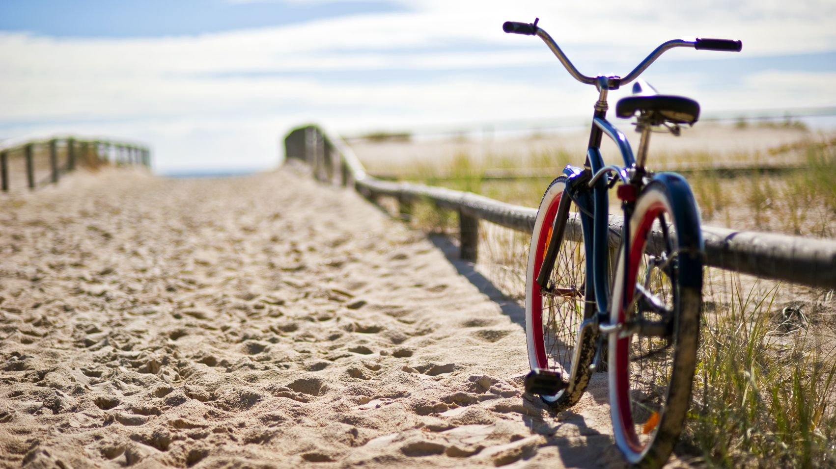 Fahrrad steht angelehnt am Zaun vom Strandübergang