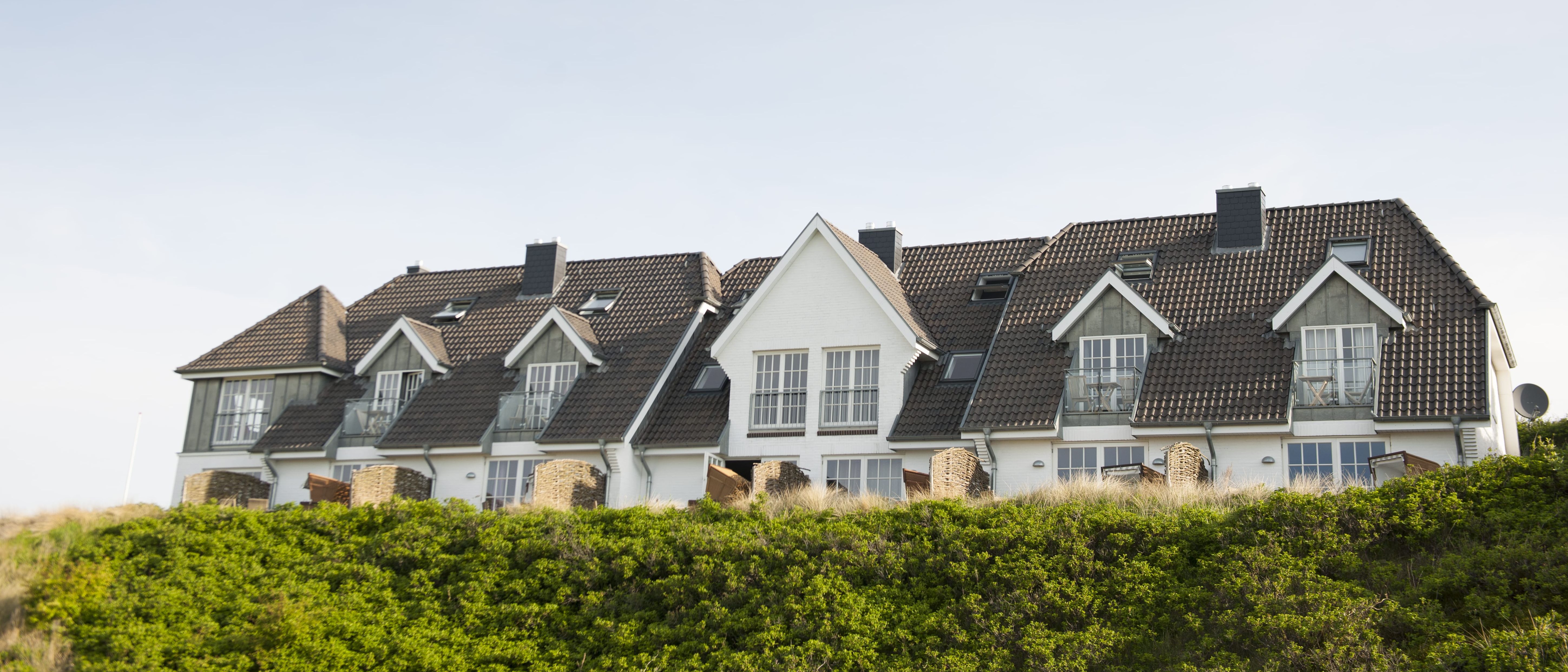 Headerbild vom Seepferdchen ApartHotel Sylt mit Außenansicht und grünem Hügel